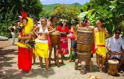 Rot und gelb gekleidete Tänzer mit Trommeln auf den Marquesas Inseln