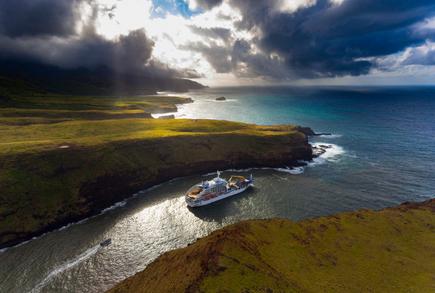 The mail and freight ship Aranui 5 in a South Seas panorama of the Marquesas island Ua Huka
