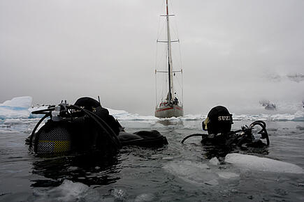 Zwei Eismeertaucher bei ihrer Expedition in die Antarktis mit Blick auf die Santa Maria Australis