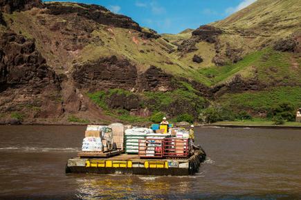 Aranui 5 Cargo Transport auf dem Wasser Richtung Land vor grünen Hügeln und blauem Himmel