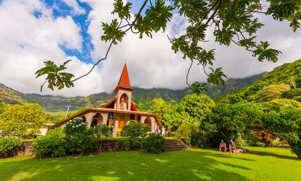 Kirche vor grünen Hügeln und blauem Himmel auf Tahuata, Marquesas Inseln, Französisch-Polynesien