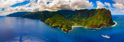 Aerial view of a bay with the Aranui, with green hills on Fatu Hiva, French Polynesia
