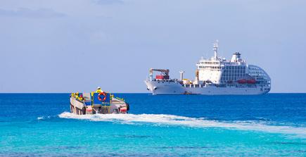 Das Frachtschiff Aranui 5 mit Beiboot zur Walbeobachtung bei dem Rangiroa Atoll, Französisch-Polynesien