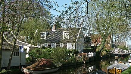Malerische Ansicht von Häusern und Booten auf Rad- und Schiffreise bei Waterland, Niederlande