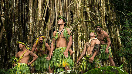 Marquesas dancer in folklore dress against dense jungle background, French Polynesia